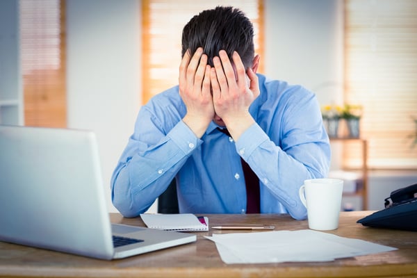 Man at work with head in hands, having a mini-breakdown